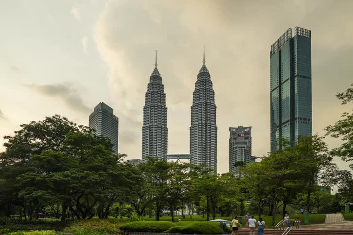 Petronas twin towers under a grey sky at sunset
