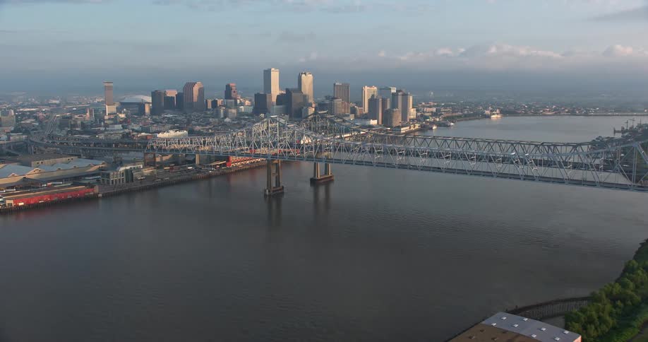 A breathtaking 4K aerial sunrise view of Crescent City Connection and Downtown New Orleans with a large bridge over the Mississippi River and the citys skyline in the background