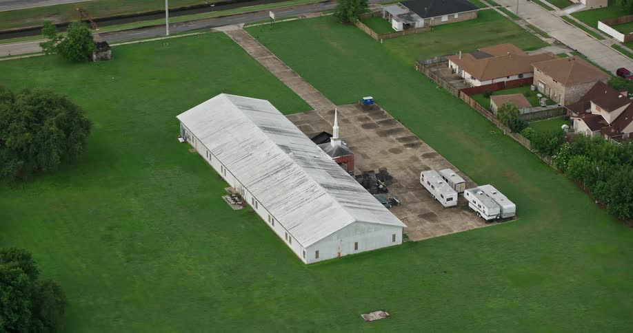 Aerial view of a small church in New Orleans East orbiting during sunrise