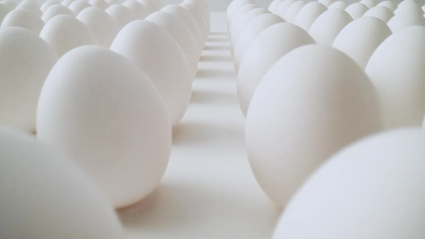 Raw shelled eggs are on display on a table