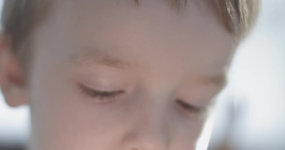 A little boy is working on something with a pencil