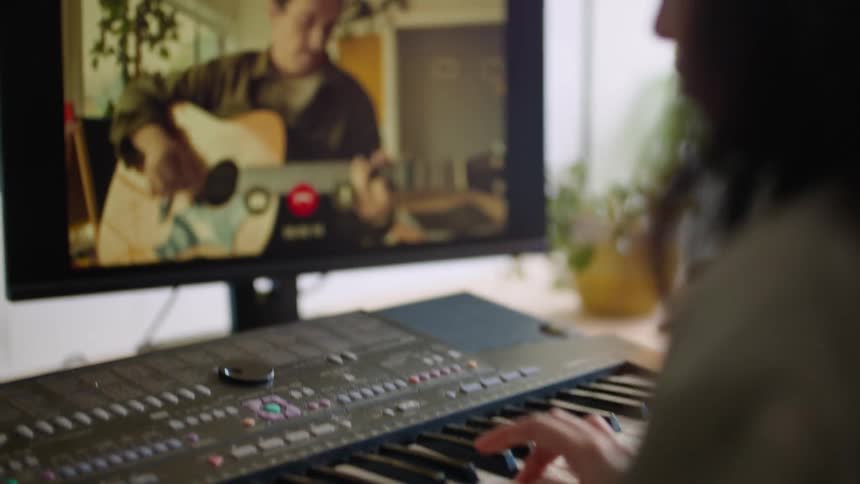 A man and woman play instruments over a video call