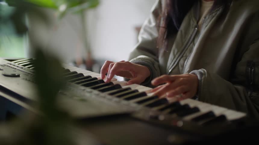 A woman playing a piano in a room