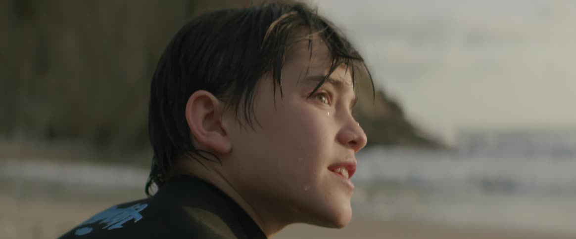 A boy is sitting on the beach