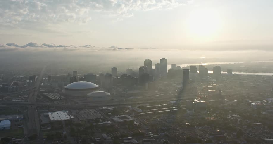 Stunning 4K aerial footage of Downtown New Orleans and Superdome glowing in the sunrise perfect for showcasing the bustling metropolis and sports entertainment hotspots of Louisiana
