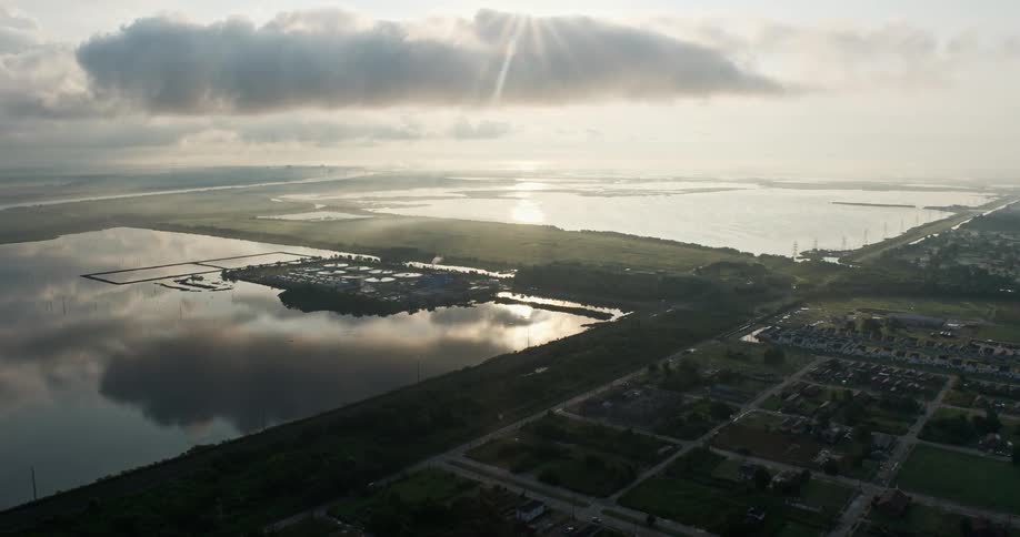 An aerial flyover of the Lower Ninth Ward neighborhoods approaching the water treatment plant at sunrise in New Orleans Louisiana