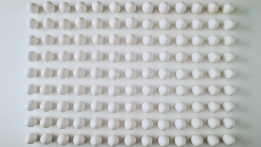Multiple eggs in a square shape on a white floor