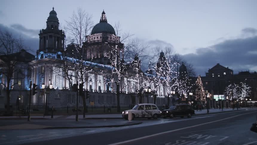 A large building is lit up at dawn