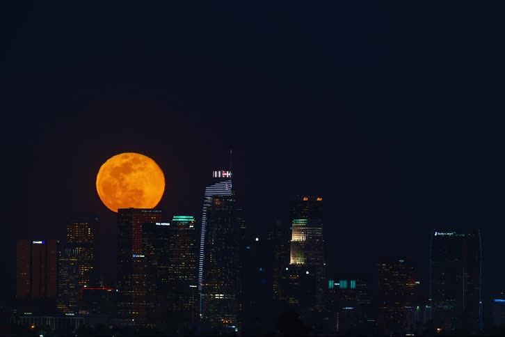Time lapse view of the moon above a downtown city
