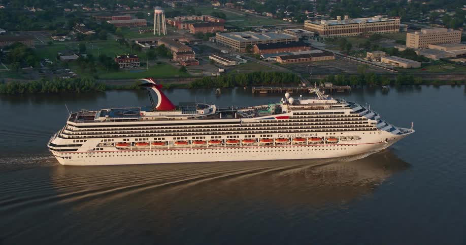 A 4K aerial footage of a Carnival Cruise ship sailing along Mississippi River before revealing Downtown New Orleans at sunrise Louisiana