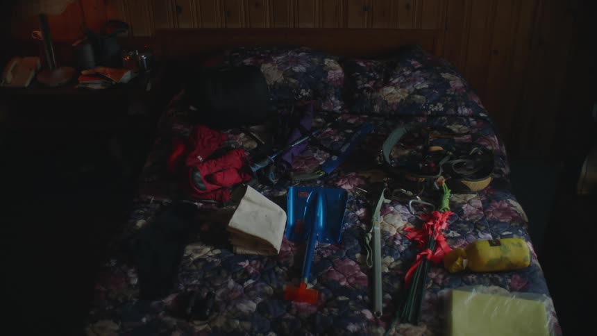 Mountaineering equipment neatly organized over a bed in a room
