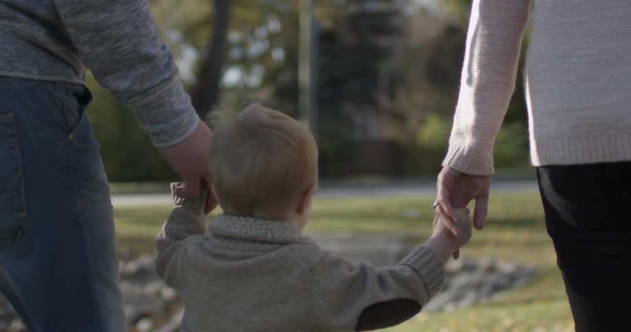 Couple walking with their children hand-in-hand