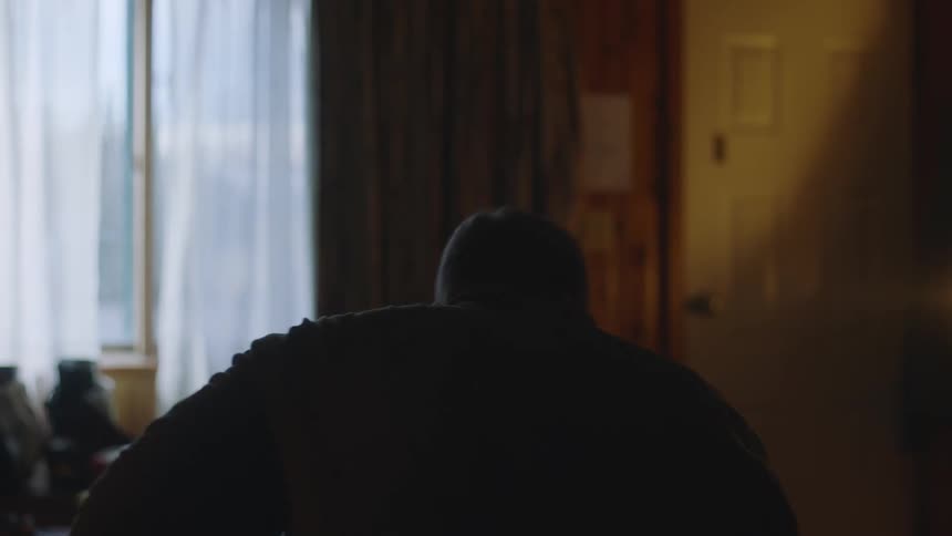 A man is walking and sits down in a chair