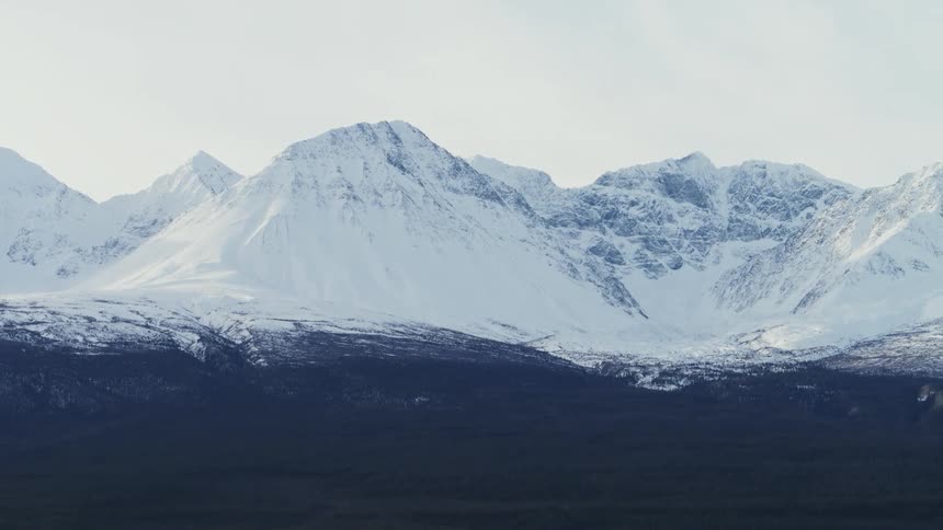 A thick blanket of snow covers a vast mountain range