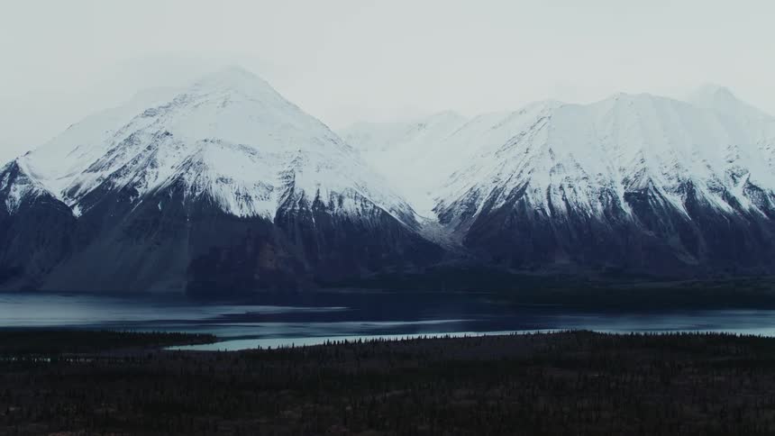 Landscape of snowy mountains next to river