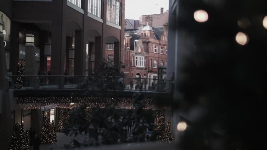 People walk past buildings in the distance