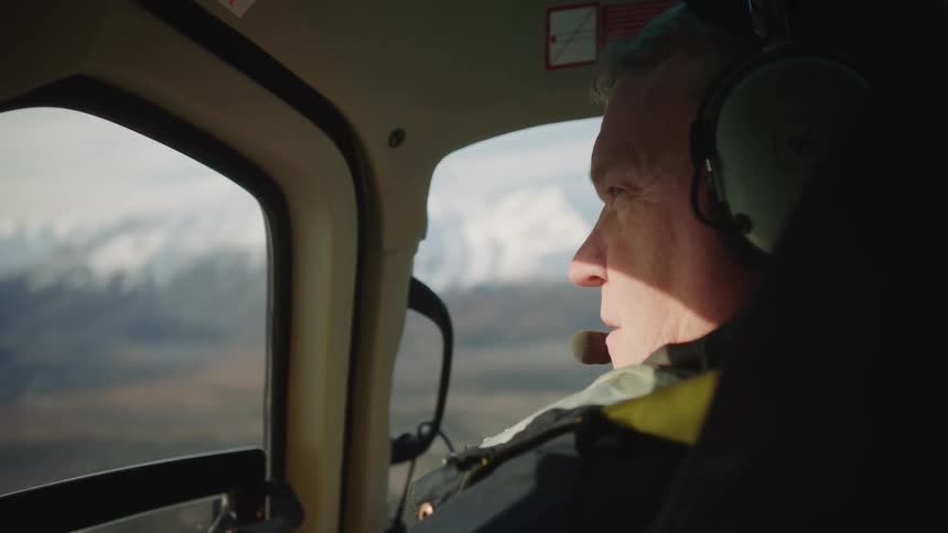 A man is riding in a helicopter