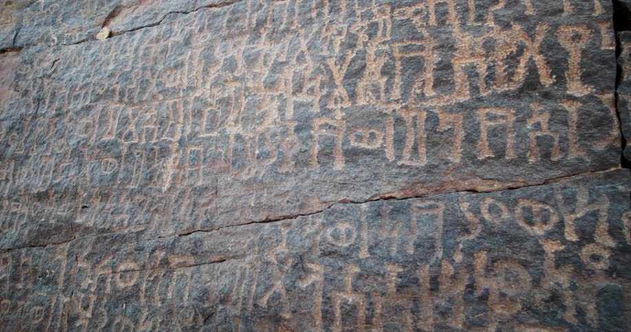 Ancient wall carvings on a stone wall in Saudi Arabia