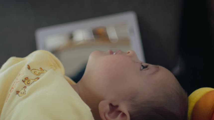 Baby lies on their back, kicking its feet at home