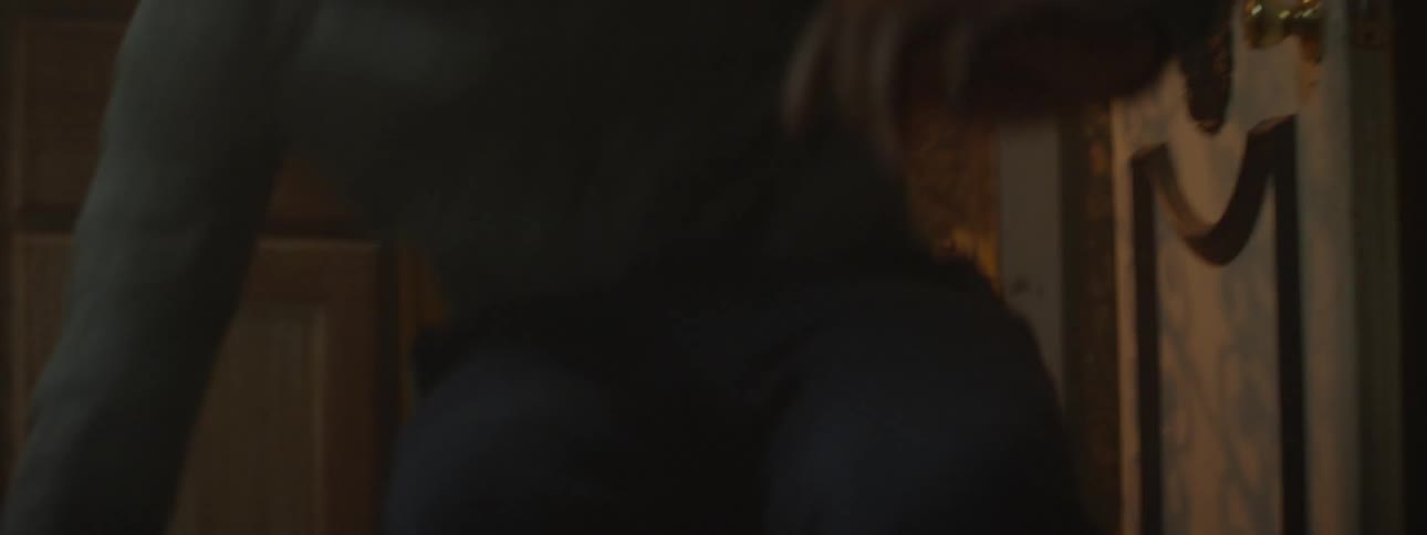 A scared looking child rushes through a screen door and sits down