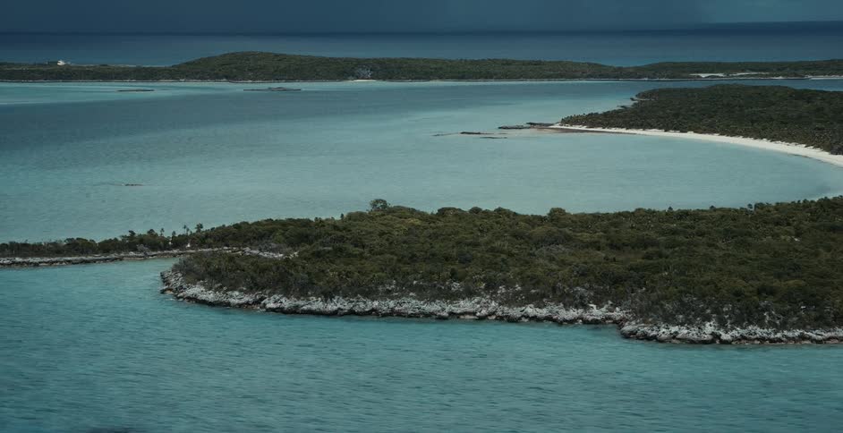 Aerial of clear blue water surrounding islands in the ocean