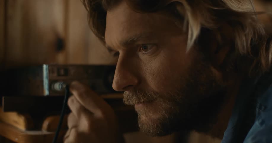 Man listens carefully while adjusting electronic device