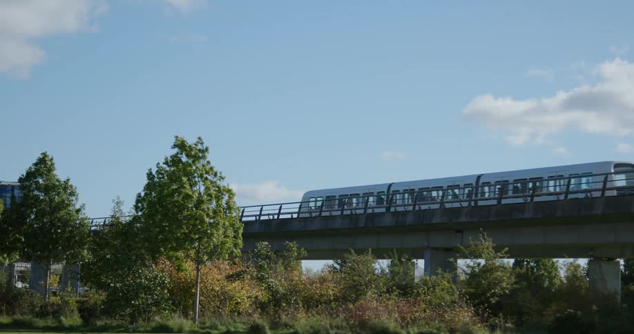 A train traveling on a bridge going to a city