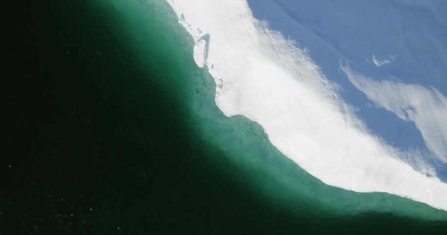 Birds eye view of an iceberg in the ocean is displayed