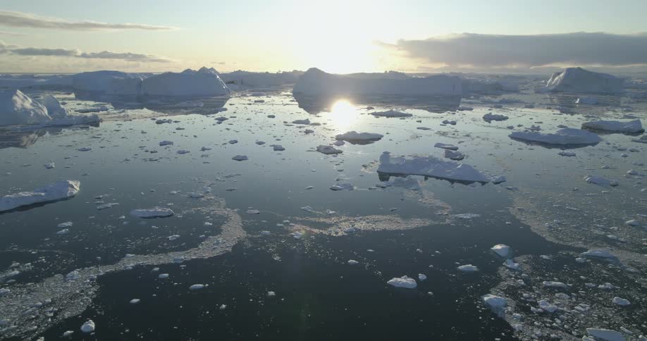 Icebergs in the ocean water is displayed at dusk