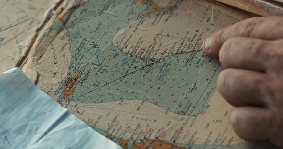 A man points to a place on a map and moves his finger along a path marked