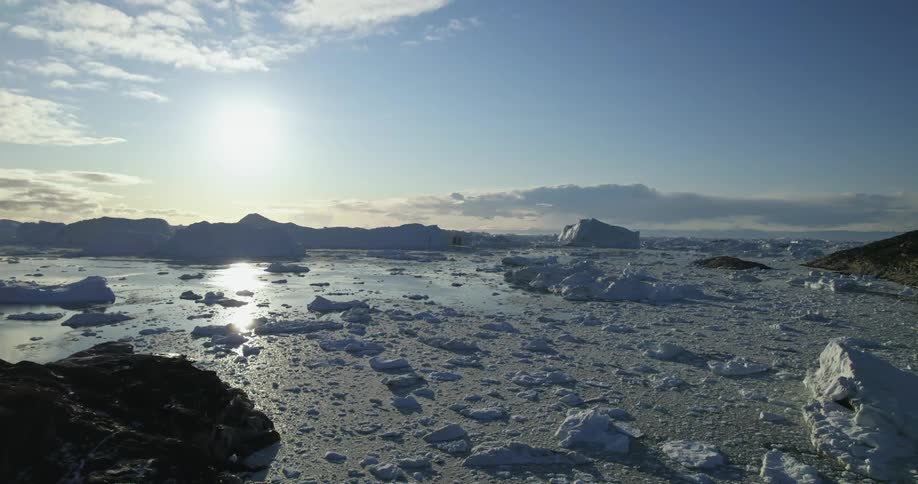 An ocean during winter is displayed at dusk