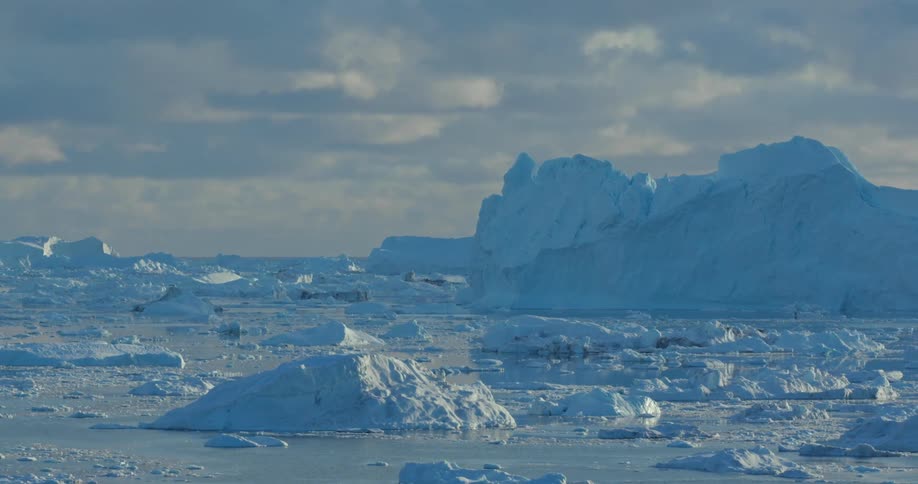 View of large glaciers and ice chunks floating in the arctic ocean at morning