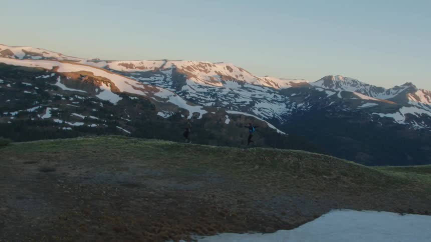 Two people are jogging outdoors during the winter