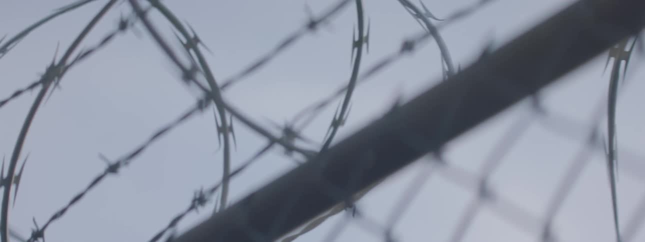 A barbed wire topped fence