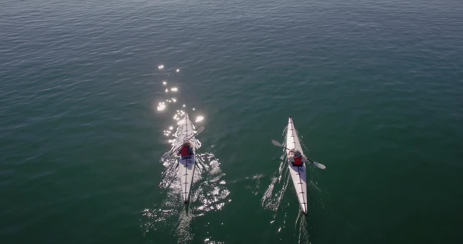 Two kayakers paddling in the ocean