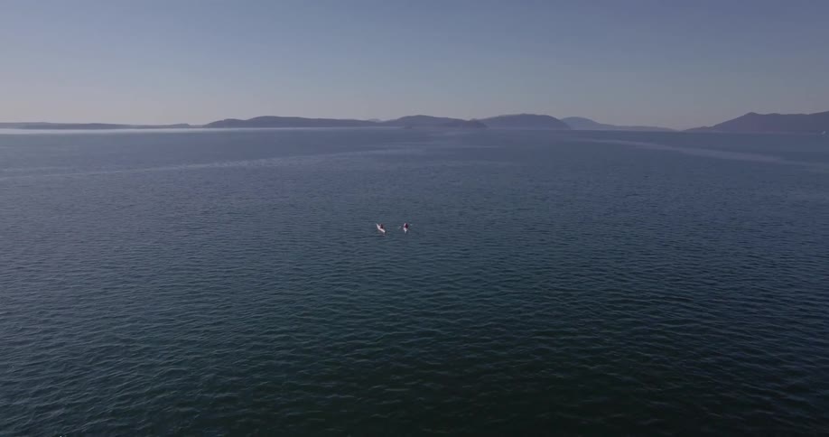 People kayak in a large body of water