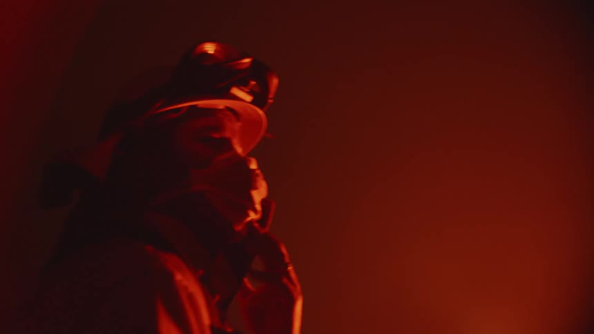 A firefighter squints while watching a fire