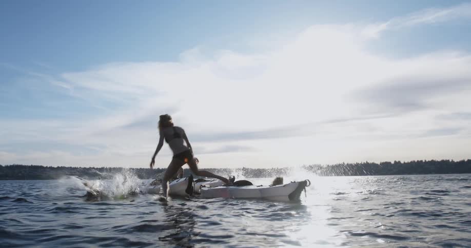 A group of friends jump from their kayaks into the water