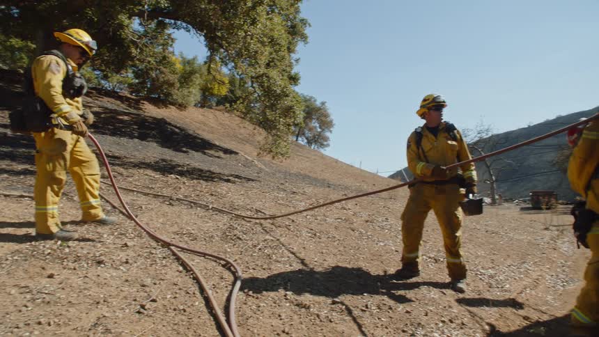 Firefighters set up their hose with the truck