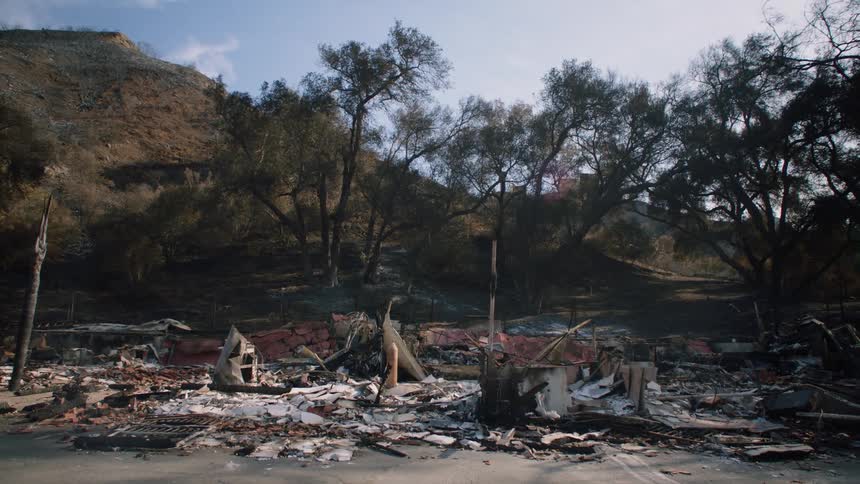 Debris indicates where a house once stood at the foot of a hill