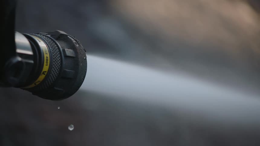 Water is spraying out of the end of a hose