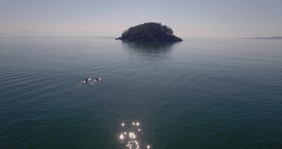 Two canoes are in the still water below
