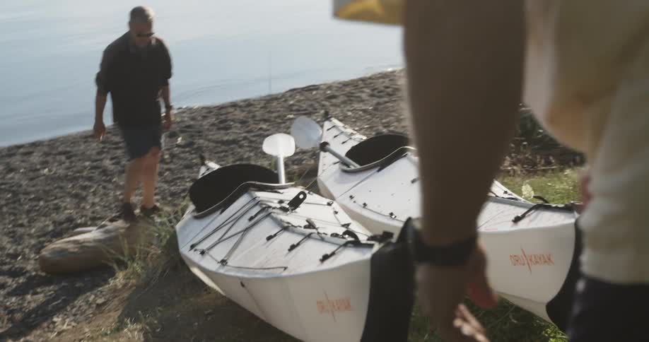 Two men get ready to push two kayaks in the water