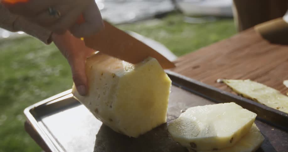 A man slices a pineapple