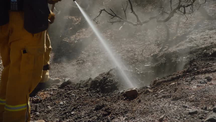 Two firefighters smother a fire