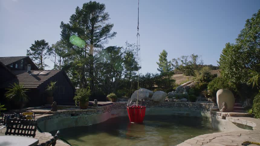 Helicopter collecting water from a backyard pool