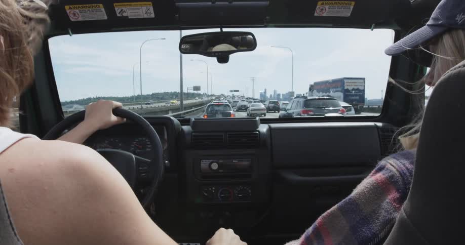 Two women driving a vehicle in traffic