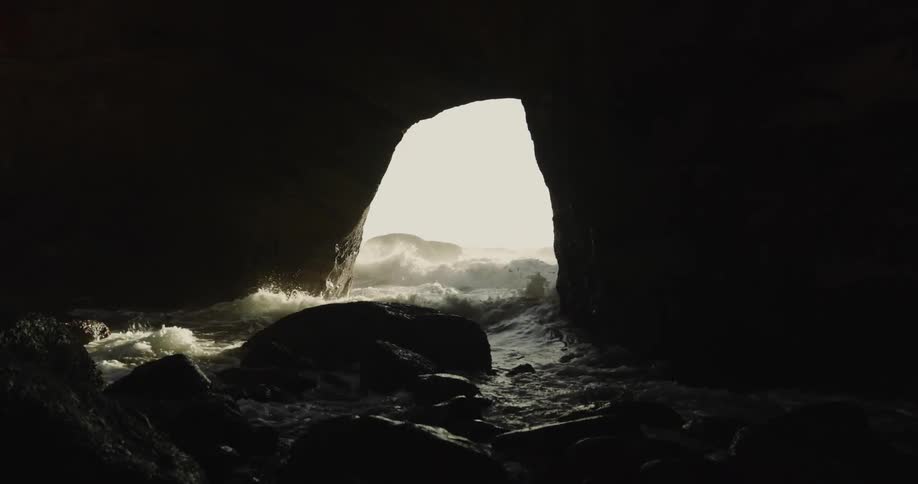 Sea cave and ocean waves breaking against the cliff