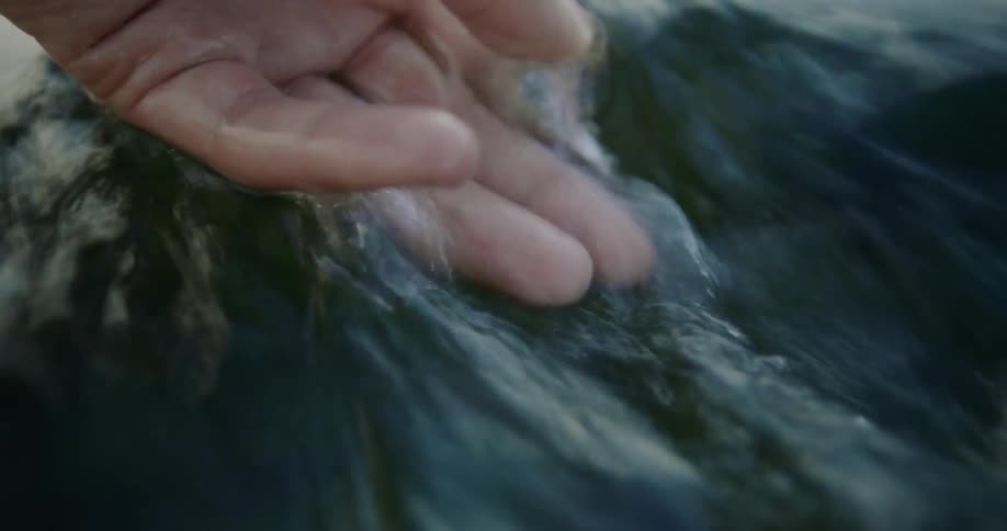 A persons hand in running water
