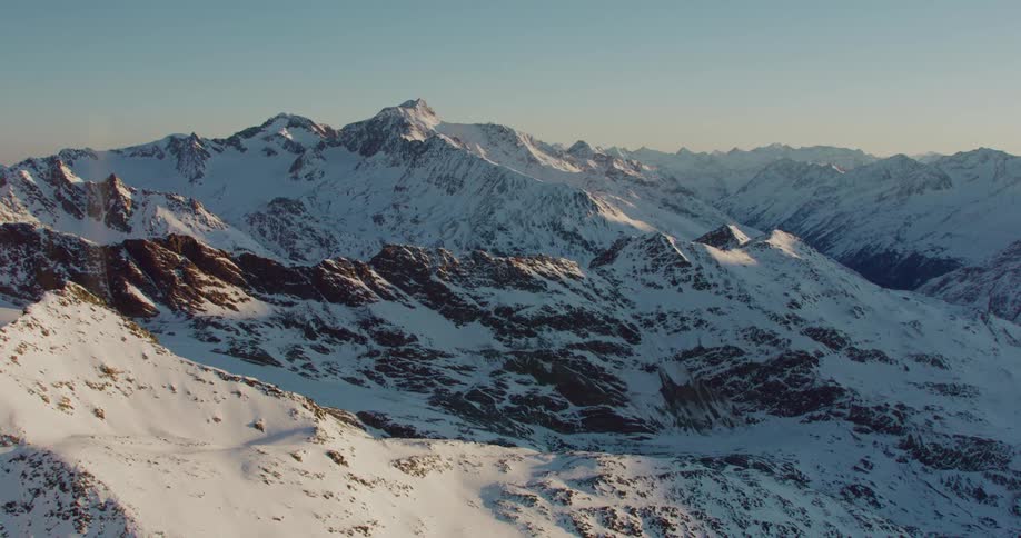 A mountain range covered in snow during the day